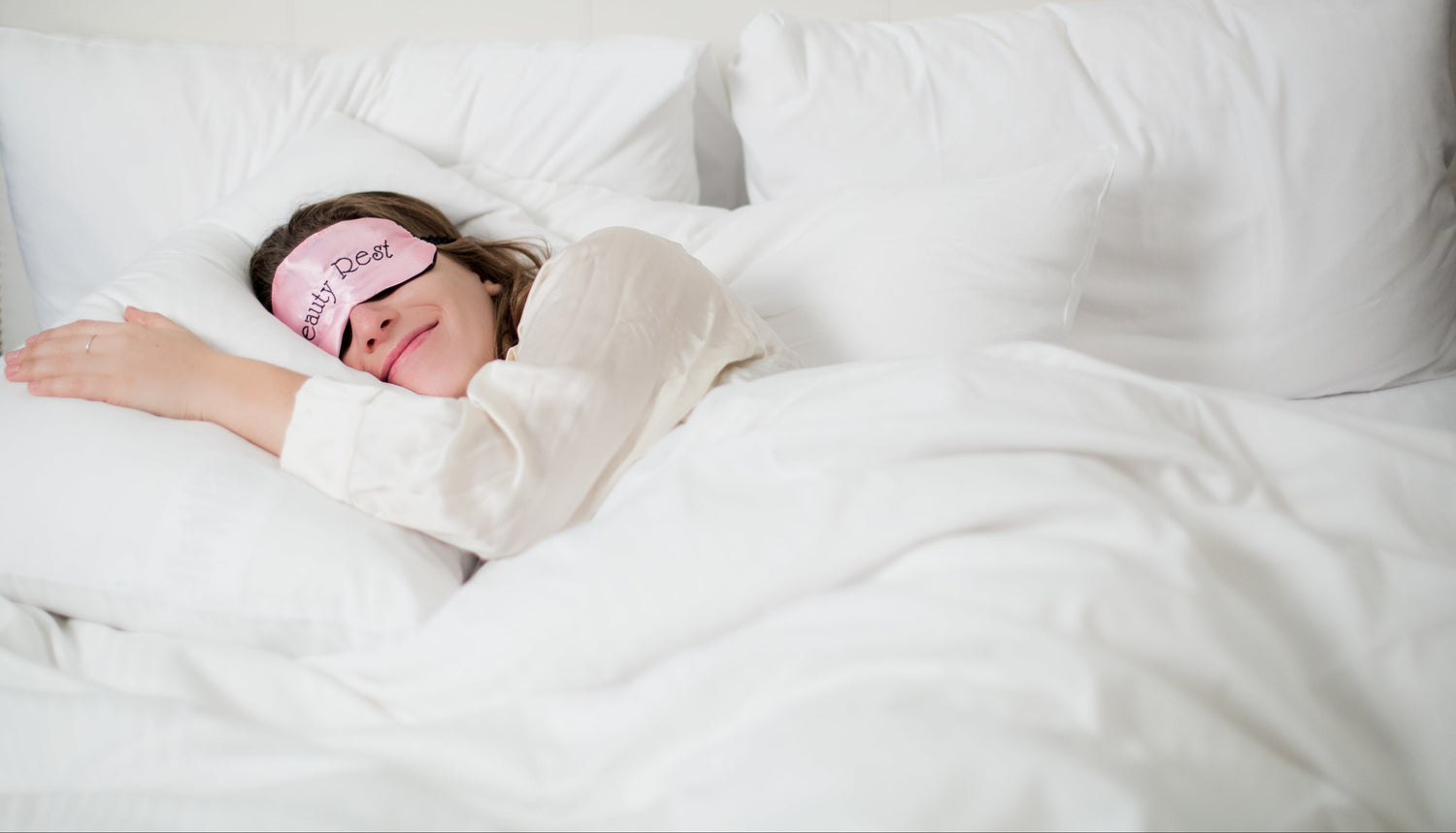 kvinde sover i seng på hotel